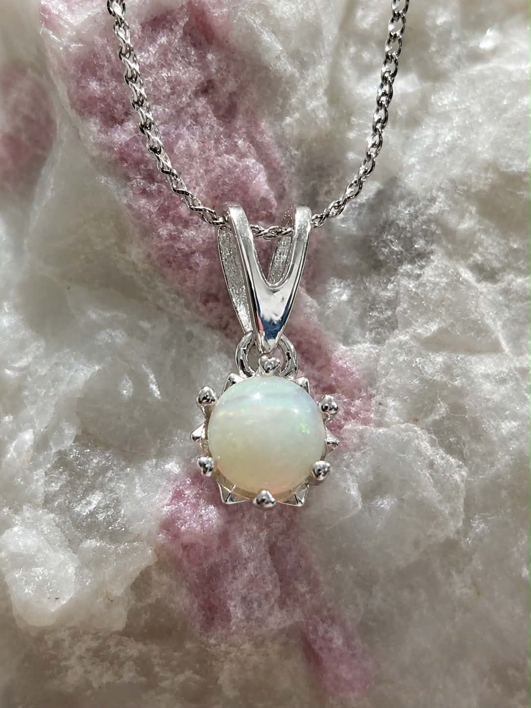 A stunning sterling silver pendant necklace featuring a round 5mm, striking white flashy opal gemstone. Red, blue and green flash. 